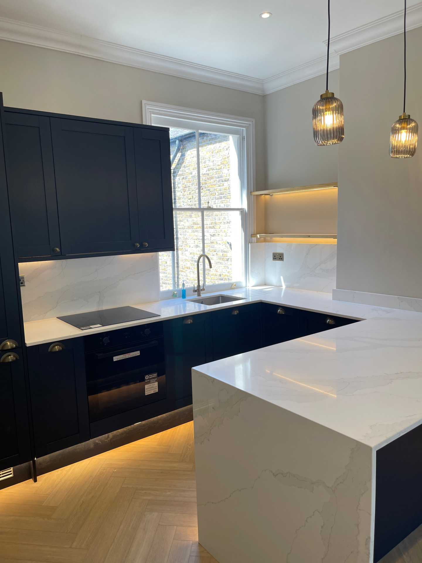 Navy shaker kitchen with marble worktops polished to a shine